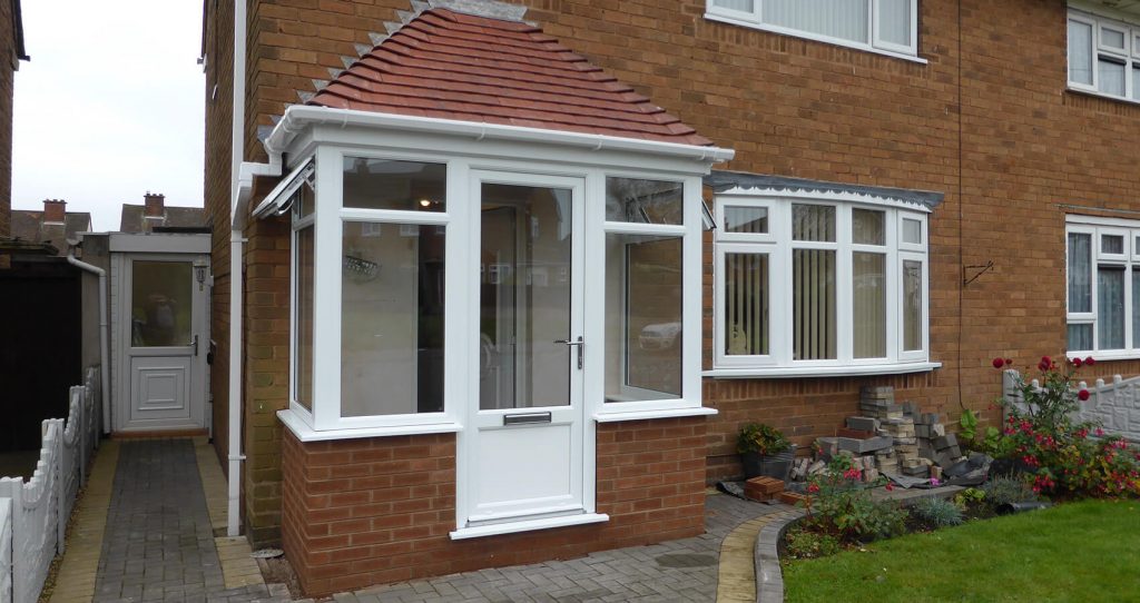White uPVC front door and porch with a red tiled roof