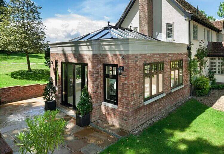 Red brick orangery with black Residence windows